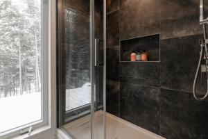 a bathroom with a glass shower with a window at Scenic Bright - Sauna - Fire - 20 min Tremblant in La Conception +26 photos