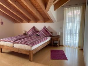 a bedroom with a bed with purple sheets and a window at Ferienhaus Eugler in Weitnau