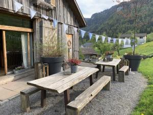 a group of picnic tables outside of a building at Evelyn's Hütte in Schwarzenberg im Bregenzerwald +33 photos