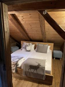 a bed in a wooden cabin with a cow on it at Evelyn's Hütte in Schwarzenberg im Bregenzerwald