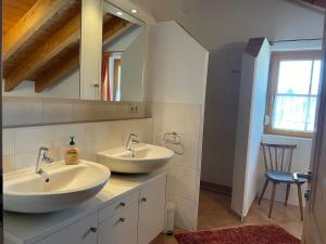 a bathroom with two sinks and a mirror at Ferienhaus Eugler in Weitnau +19 photos