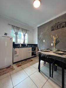una cocina con una mesa y un refrigerador en Iririu 01 · Ap térreo a 2 km - Hospital Regional Hans Dieter, en Boa Vista