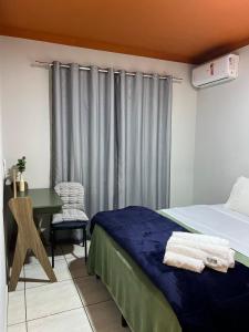 Un dormitorio con una cama y un escritorio y una ventana. en Iririu 01 · Ap térreo a 2 km - Hospital Regional Hans Dieter, en Boa Vista 56 fotos más