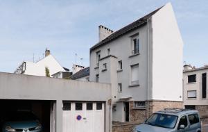 Un edificio blanco con un coche aparcado delante. en Lofoten - Îlots de Merville, en Lorient 19 fotos más