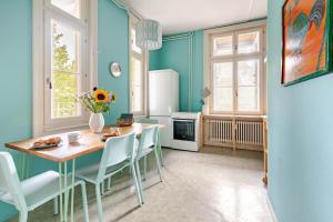 a kitchen with blue walls and a table and chairs at Historic Gem - Lift - Balcony in Basel