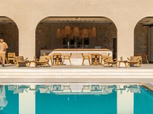 a pool with chairs and a table next to a building at Ayla Corfu in Kavos