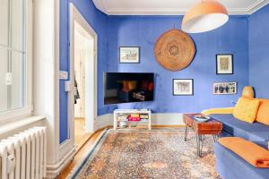 a blue living room with a couch and a table at Historic Gem - Lift - Balcony in Basel