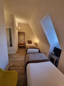 a attic room with three beds in a room at Amadour Hôtel in Rocamadour
