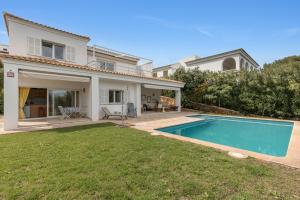 een huis met een zwembad in de tuin bij Villa Tres in Es Mercadal