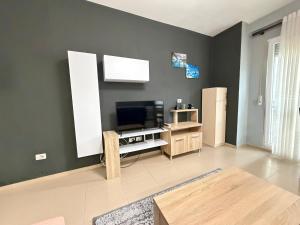 a living room with a flat screen tv on a wall at Riva'S Apartament in Shkodër
