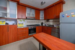 a kitchen with wooden cabinets and a white refrigerator at Hostal Casa Macondo in Santa Marta