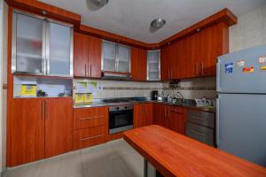 a kitchen with wooden cabinets and a white refrigerator at Hostal Casa Macondo in Santa Marta +41 photos