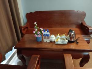 a wooden table with drinks and flowers on it at RatanakCity hotel in Banlung