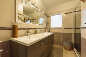 een badkamer met een wastafel en een spiegel bij Villa Goya in Ares with private pool in Arès