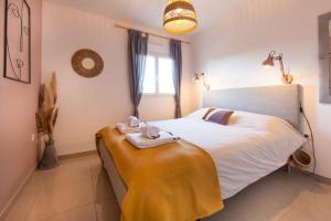 een slaapkamer met een bed met handdoeken erop bij Villa Goya in Ares with private pool in Arès