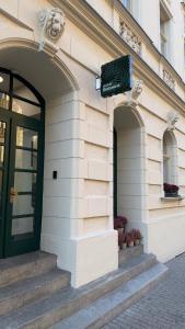 a building with a green door and a sign on it at Hotel Botanica by goodnite cz in Brno