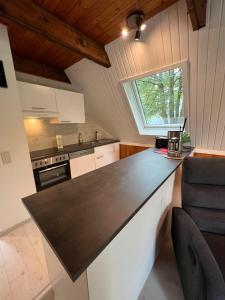 a kitchen with a black counter top and a window at Twistesee Ferienhaus 42 in Wetterburg +3 photos