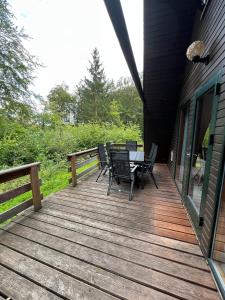 a wooden deck with chairs and a table on it at Twistesee Ferienhaus 42 in Wetterburg