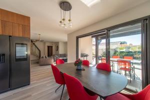 a kitchen and dining room with a table and red chairs at Villa Fabienne in city center with heated pool in Andernos-les-Bains