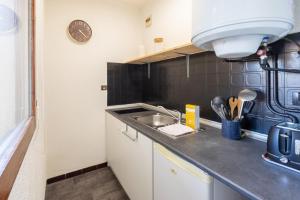 アンデルノ・レ・バンにあるStudio Les Vacances a Andernosの小さなキッチン(シンク、壁掛け時計付)