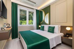 a bedroom with a green and white bed and a window at Sistina Old City Hotel in Istanbul