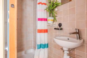 ein Badezimmer mit Waschbecken und Duschvorhang in der Unterkunft Jeux de boules 3 in Le Pradet