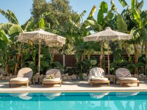 a group of chairs and umbrellas next to a pool at Ayla Corfu in Kavos