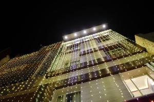 a tall building with lights on it at night at Om Palace Inn in Varanasi