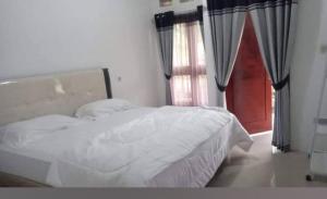 a bedroom with a white bed and a window at Najwahomestay in Lombok International Airport