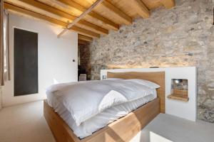 a bedroom with a large bed in a stone wall at Casa Limonaia al Pos in Tignale