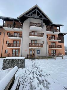 a building with snow in front of it at Résidence Les Lumières des Neiges et parking in Valmeinier
