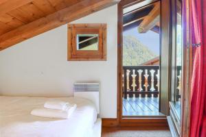 a bedroom with a bed and a large window at Amethyste - 2 Bedrooms & Free Parking - By Cozee Rentals in Les Houches