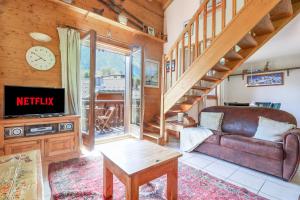 a living room with a couch and a tv at Amethyste - 2 Bedrooms & Free Parking - By Cozee Rentals in Les Houches