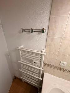 a bathroom with a toilet and a towel rack on the wall at Résidence Les Lumières des Neiges et parking in Valmeinier +30 photos