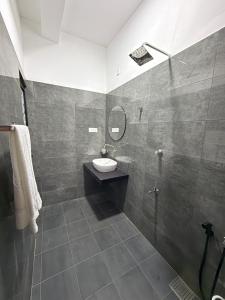 een badkamer met een wastafel en een spiegel bij Dewliya Rest in Galle
