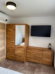 a bedroom with a flat screen tv on a wall at Ferienhaus Am Nationalpark 8A in Klausdorf Mecklenburg Vorpommern