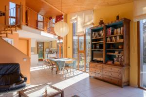 a living room with yellow walls and a wooden bookcase at Gîte Du Kiwi in Luttenbach-près-Munster