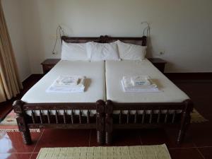 瓦尔卡拉Seashore Beach Resort Varkala的房间里有一张床，上面有两个枕头