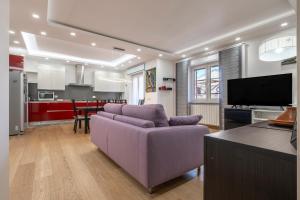 Il comprend un salon avec un canapé violet et une cuisine. dans l'établissement Casa Fenicotteri, à Orbetello