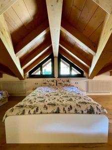 a bedroom with a large bed in a room with wooden ceilings at Sogno Alpino in Caspoggio