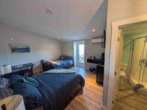 a bedroom with a bed and a living room with a window at Dildo Boathouse Inn in Dildo