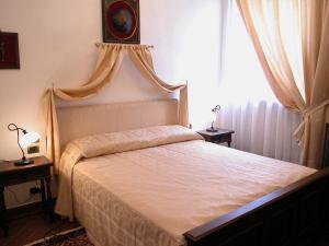 1 dormitorio con cama y ventana en Palazzo Tarlati - Hotel de Charme - Residenza d'Epoca en Civitella in Val di Chiana