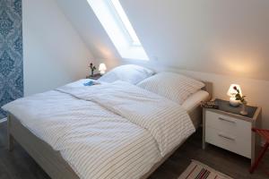 a bedroom with a white bed with a window at Ferienhaus Brise in Boren