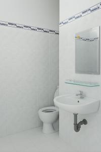 Un baño blanco con inodoro y lavabo. en CKC Motel - Near Can Tho City Center, en Can Tho