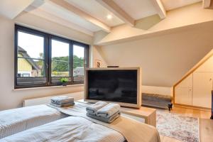 Μια τηλεόραση ή/και κέντρο ψυχαγωγίας στο Ferienhaus Küstenhuus 20 Feriendorf Klein Stresow Rügen by ruyastay