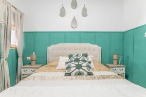ein Schlafzimmer mit einem weißen Bett mit grünen Wänden in der Unterkunft Casa bohemia in Arcos de la Frontera
