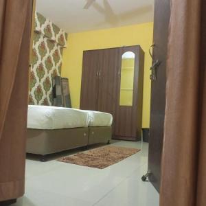 Un dormitorio con una cama y una puerta de madera. en The Royals Home Stay, en Deoghar