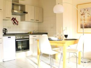 a kitchen with a wooden table and white chairs at Solveigs Ferienwohnung in Bad Münstereifel