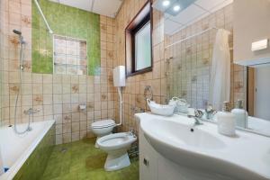 une salle de bain avec un lavabo, des toilettes et une baignoire dans l'établissement Appartamento immerso nel verde, à Lanzo dʼIntelvi 18 autres photos