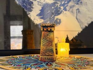 a candle sitting on a table next to a lighthouse at Irbis hotel in Mestia